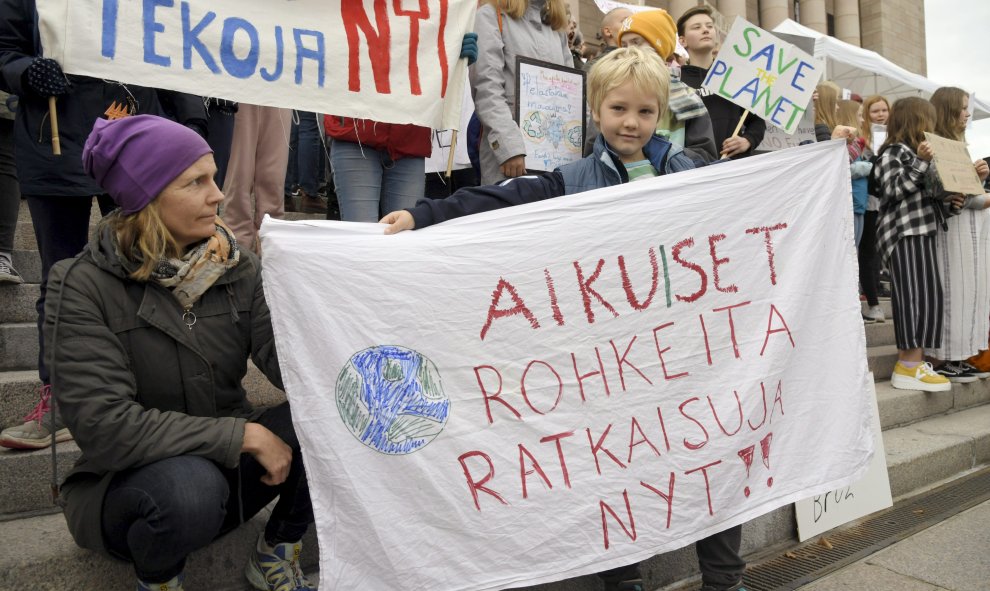 Finlandia, Helsinki: un niño sostiene un cartel en la Casa del Parlamento. Foto: Markku Ulander / Lehtikuva / dpa