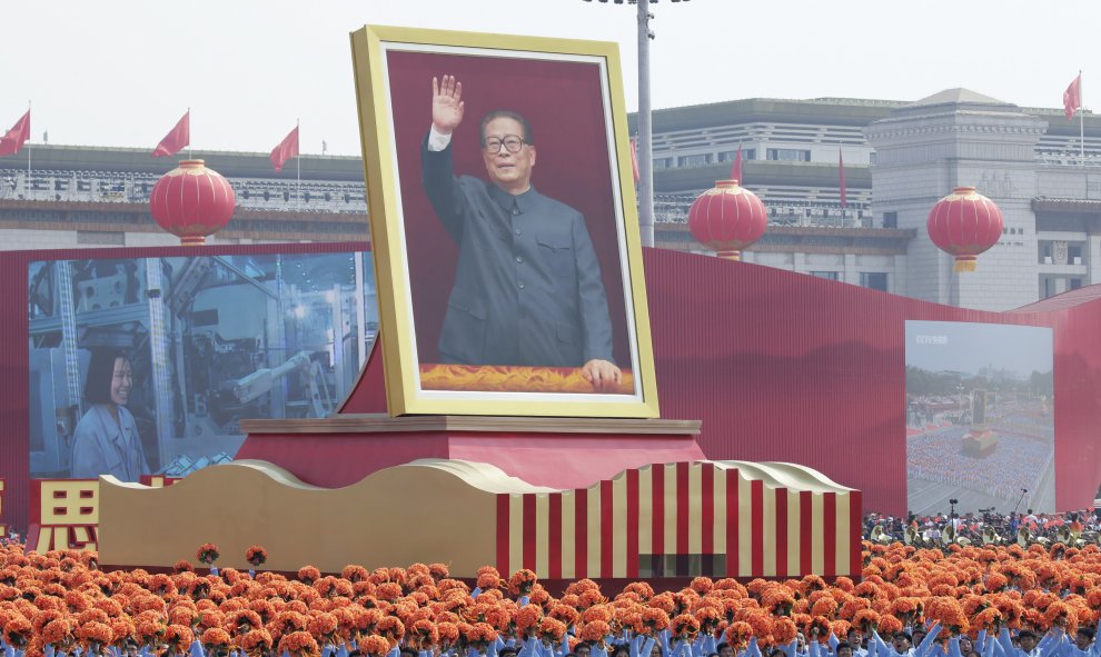 Ciudadanos caminan por la avenida Changan con una carroza que muestra al ex presidente chino Jiang Zemin. REUTERS / Jason Lee