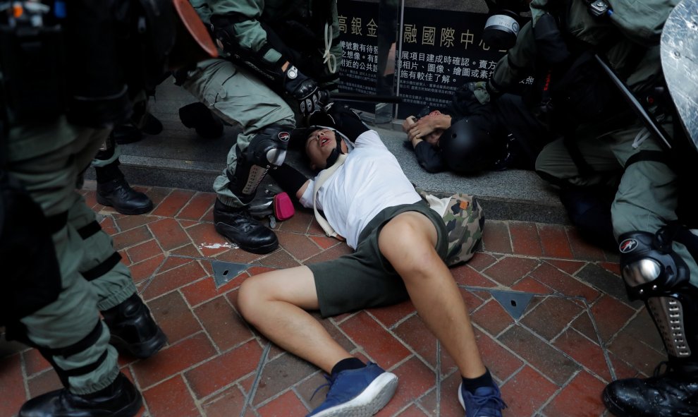 La policía antidisturbios detiene a un manifestante antigubernamental durante una manifestación en el distrito de Wan Chai. REUTERS / Susana Vera