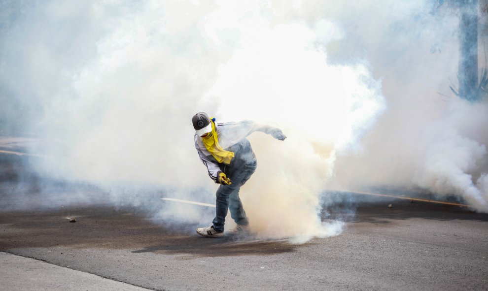 Un joven con una máscara rodeado de gas lacrimógeno. / Europa Press -  Juan Diego Montenegro