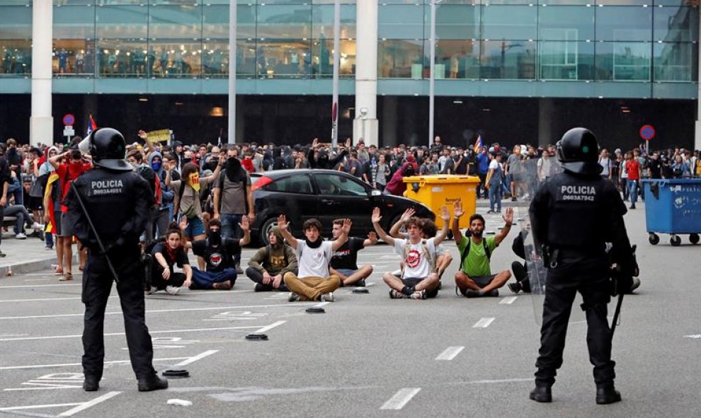 14/10/2019.- Miembros de los Mossos d'Esquadra controlan a las centenares de personas que se agolpan ante el Aeropuerto del Prat. EFE/ Toni Albir