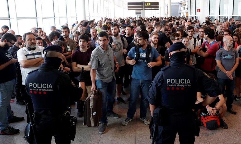 14/10/2019.- Agentes de los Mossos d'Esquadra y de la Policía Nacional controlan el acceso de personas a la terminal 1 del Aeropuerto de El Prat. EFE/Alejandro García