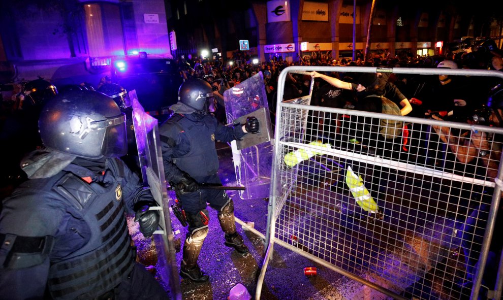 Los Mossos se enfrentan a los manifestantes con las vallas entre medias en las calles céntricas de Barcelona. /REUTERS