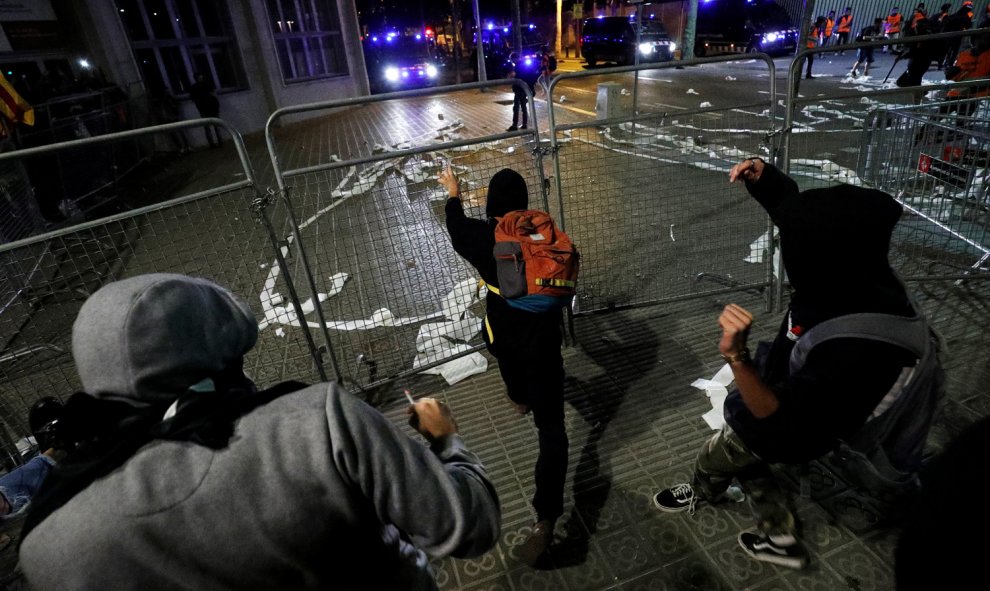 Varios hombres encapuchados lanzan objetos ante los furgones policiales en el centro de Barcelona. /REUTERS