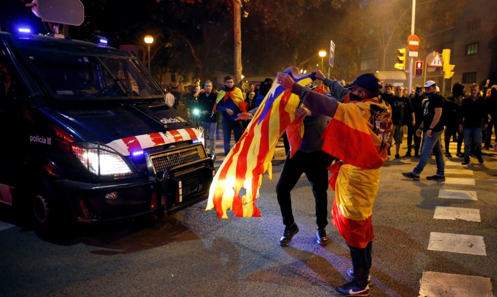 17/10/2019 - Un hombre vestido con la bandera franquista muestra la estelada al furgón de la policía durante las protestas de los CDR en barcelona. / REUTERS (Rafael Marchante)
