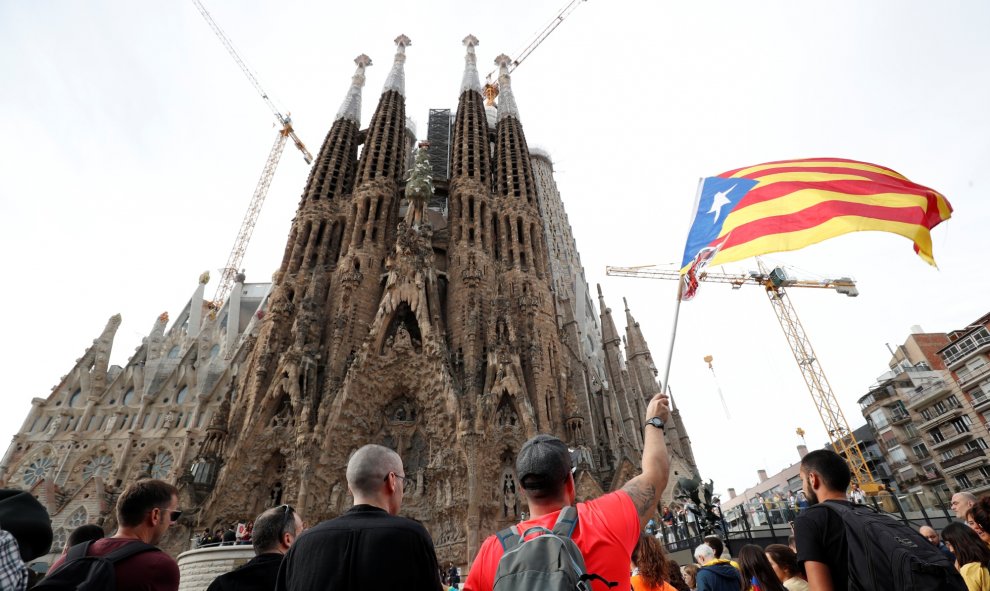 18/10/2019 - Un manifestante catalán agita una Estelada frente a la Sagrada Familia durante la huelga general de Cataluña en Barcelona. / REUTERS (Albert Gea)