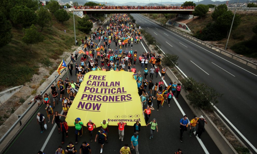 18/10/2019m - Los manifestantes portan una pancarta gigante en uno de los cortes de la autopista en Catalunya durante la huelga general de este viernes./ AFP (Pau Barrena)