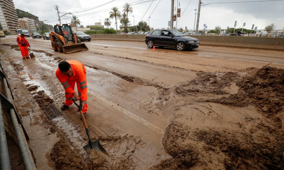 23/10/2019.- Los trabajadores eliminan el lodo de la carretera N-II después de las inundaciones causadas por lluvias torrenciales en Arenys de Mar, al norte de Barcelona. REUTERS / Albert Gea