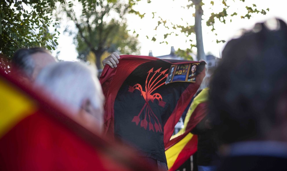 Un hombre sostiene una bandera de la Falange y una foto del dictador cerca del cementerio Mingorrubio-El Pardo. / Jairo Vargas