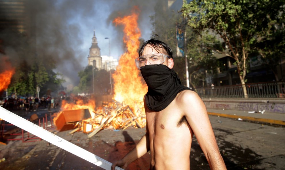 28/10/2019.- Manifestantes participan en una protesta por décimo día consecutivo, contra el Gobierno de Sebastián Piñera este lunes, frente al Palacio de la Moneda en Santiago (Chile). Una marcha este lunes hacia el Palacio de La Moneda para expresar fren