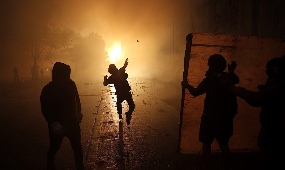 28/10/2019.- Un manifestante participa en una protesta contra el Gobierno de Sebastián Piñera este lunes, en Santiago (Chile). Una marcha se dirigió hacia el Palacio de La Moneda para expresar frente a la sede del Gobierno el descontento social de las pro