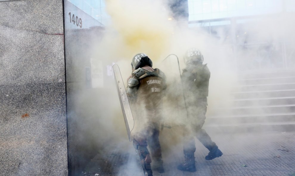 29/10/2019 - Policías antidisturbios envueltos por vapores de extintores durante la protesta contra el gobierno en Santiago, Chile. REUTERS / Pablo Sanhueza