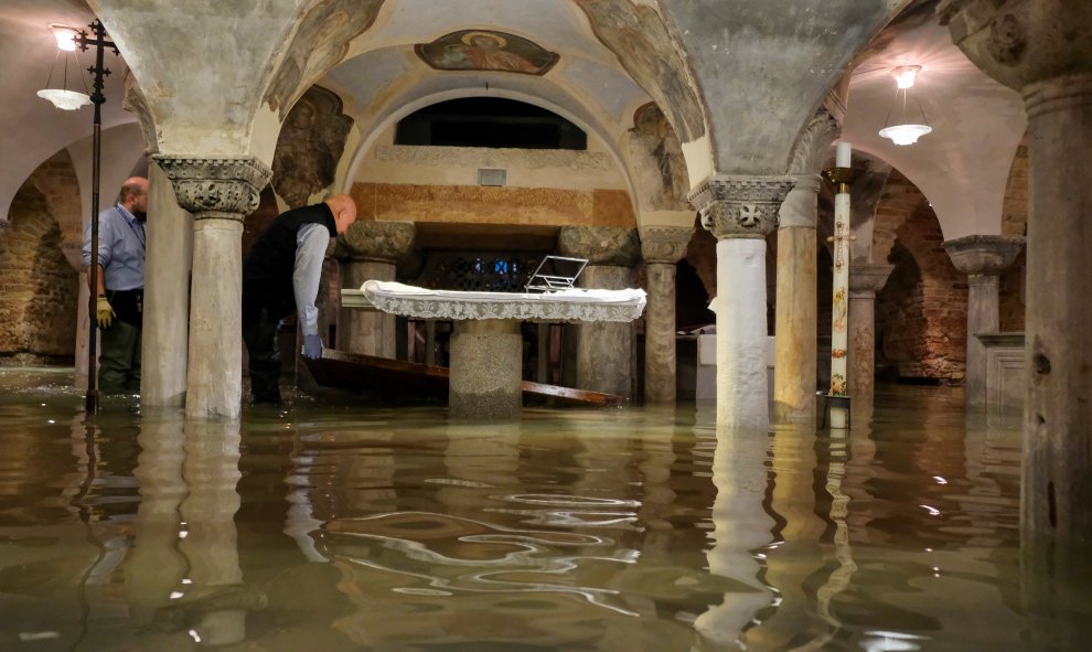 Operarios vacían la cripta de la basílica de San Marcos, donde el nivel del agua llegó a los 110 centímetros durante la noche. REUTERS/Manuel Silvestri