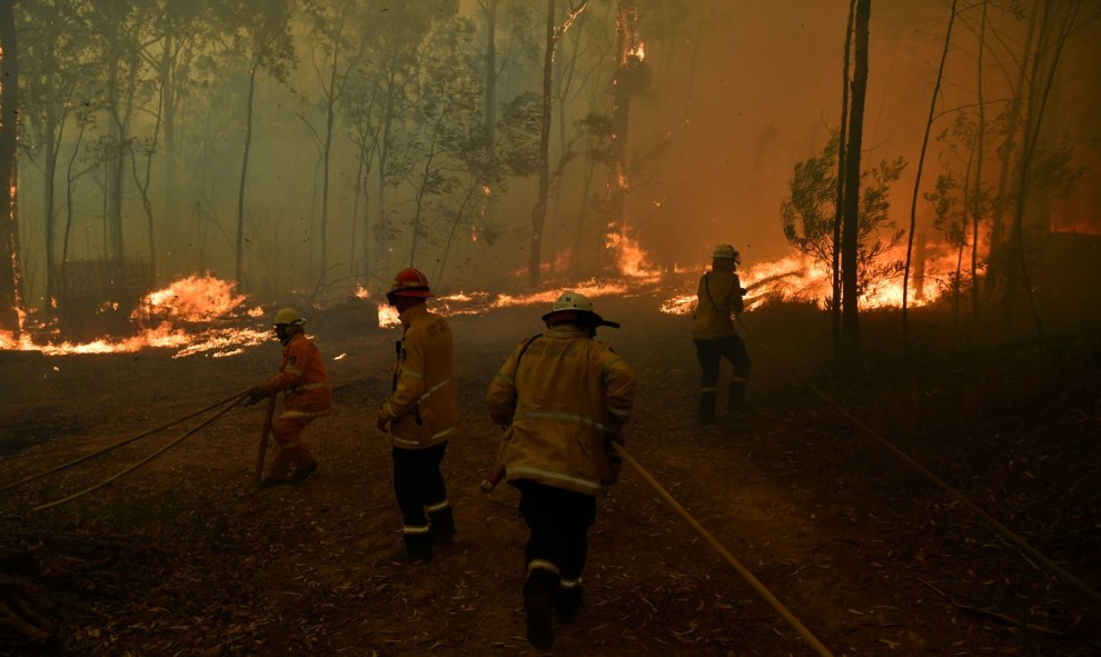 19/11/2019- Los voluntarios de RFS y los oficiales de bomberos y rescate de NSW protegen una casa en Wheelbarrow Ridge Road que se ve afectada por el incendio de Gospers Mountain al suroeste de Sídney, Australia. / AAP / Dean Lewins / REUTERS