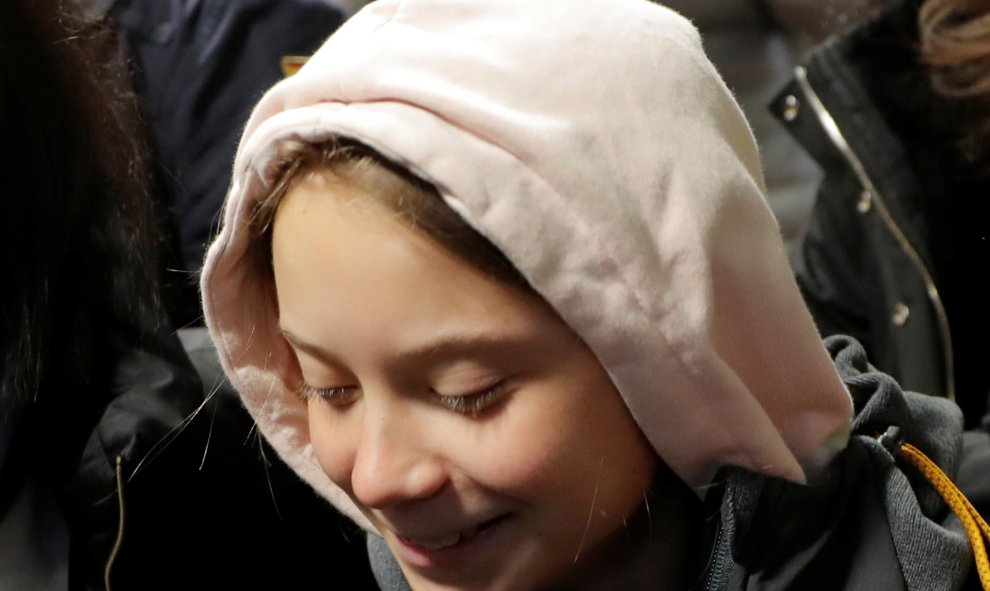 Greta Thunberg sonría mientras baja del tren que le ha traído desde Lisboa a Madrid, donde acudirá a Marcha por el Clima./ REUTERS