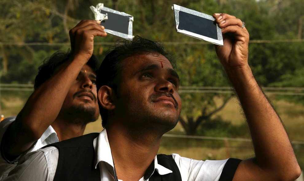 26/12/2019.- Dos personas usando vidrio oscuro para ver el eclipse solar en Mysore, India. EFE / EPA / JAGADEESH NV