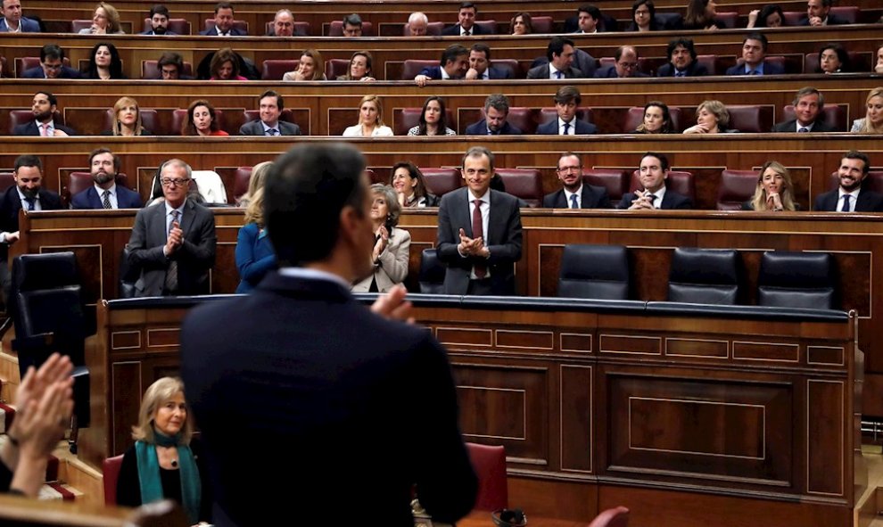 El candidato a la Presidencia del Gobierno, Pedro Sánchez (de espaldas) observa la bancada del PP y Vox tras finalizar su discurso en el Congreso de los Diputados durante la primera jornada de la sesión de su investidura como presidente del Gobierno. EFE/