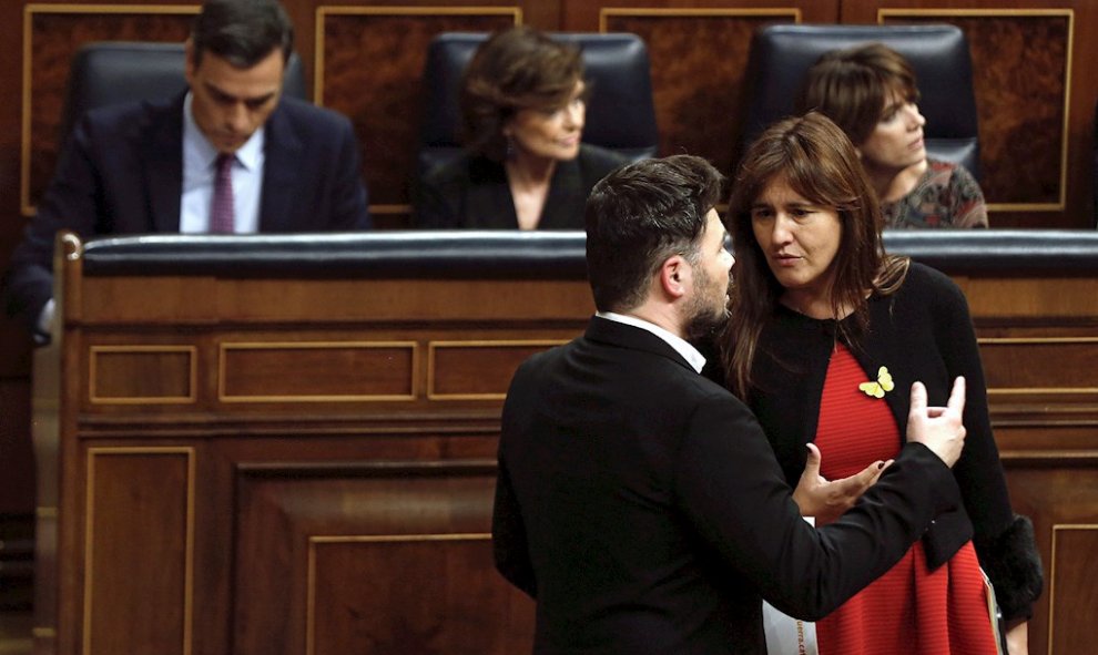 El portavoz de ERC, Gabriel Rufián (i), conversa con la portavoz de JxCat, Laura Borrás (d), ante el escaño del candidato a la Presidencia del Gobierno, Pedro Sánchez (i), en el hemiciclo del Congreso de los Diputados en la primera jornada de la sesión de