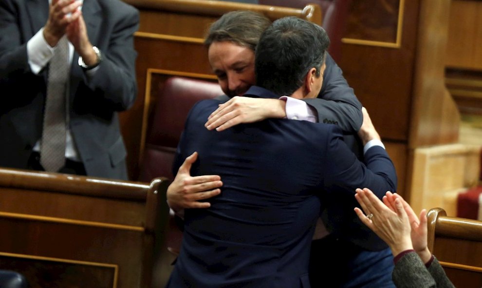 El líder de Unidas Podemos, Pablo Iglesias (i), abraza a Pedro Sánchez, tras su intervención ante el pleno del Congreso de los Diputados en la primera jornada de la sesión de investidura de Pedro Sánchez como presidente del Gobierno. EFE/Emilio Naranjo