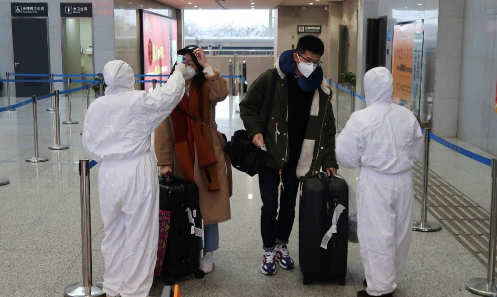 Trabajadores toman la temperatura a pasajeros de la estación de Xianning,  una ciudad que limita con Wuhan al norte. REUTERS