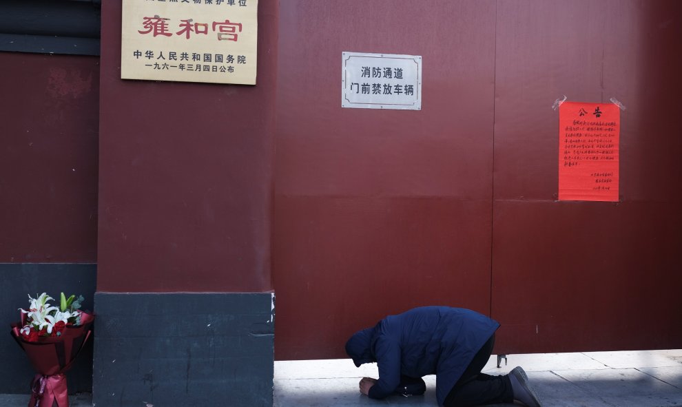 Un hombre reza fuera del templo de Yonghe en Pekín, cerrado por el brote del coronavirus. REUTERS