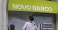 Dos operarios colocan el cartel de Novo Banco en una oficina de la entidad, en Lisboa. REUTERS