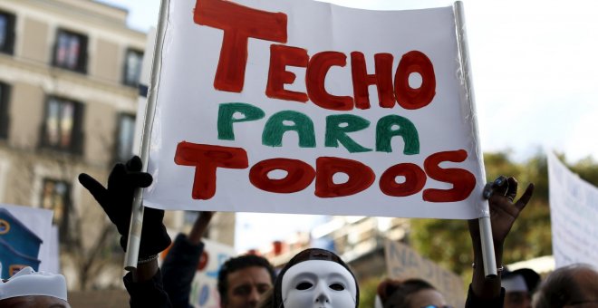 Un manifestante sujeta una pancarta donde se lee "TECHO PARA TODOS" en la protesta convocada por la plataforma "Nadie sin Hogar" por el derecho a la vivienda, en el centro de Madrid, España, 26 de noviembre de economía 2015. REUTERS / Paul Hanna