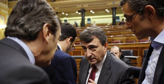 El portavoz parlamentario del PNV, Aitor Esteban, conversa con el portavoz del Grupo Popular, Rafael Hernando, en presencia del diputado socialista Eduardo Madina, durante el pleno del Congreso. EFE/Mariscal