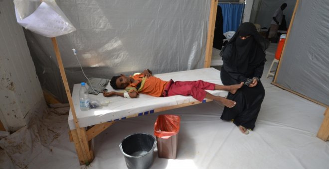 Una mujer se sienta junto a su hijo enfermo de cólera en un hospital de la ciudad de Hodeidah, Yemen.- REUTERS / Abduljabbar Zeyad