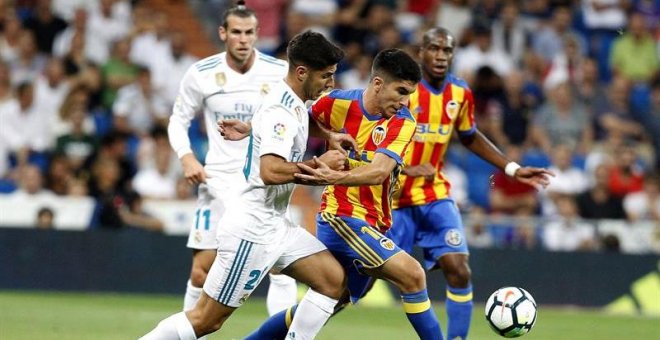 El delantero del Real Madrid Marco Asensio lucha el balón con Carlos Soler, del Valencia CF. - EFE