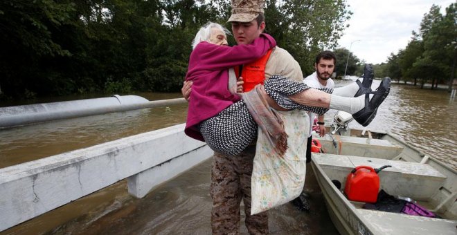 Un hombre ayuda a una anciana damnificada por Harvey en Houston. REUTERS/Carlo Allegri