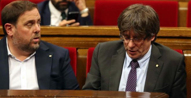 El presidente de la Generalitat, Carles Puigdemont (d) y el vicepresidente del Govern, Oriol Junqueras (i), abandonan hoy el hemiciclo del Parlament de Cataluña a los pocos minutos de iniciarse la sesión a causa de la petición del PPC de suspenderse para