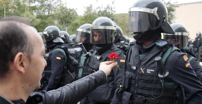 Un hombre ofrece un clavel a un agente de la Guardia Civil en el centro de votación de Sant Julià de Ramis (Girona) donde inicialmente tenía previsto votar el presidente de la Generalitat, Carles Puigdemont, en el referéndum independentista del 1-O./ EFE