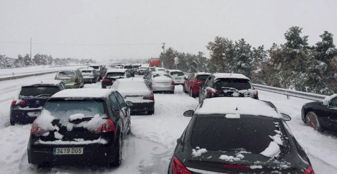 Fotografía facilitada por un conductor retenido en la A-6, a la altura del Km 75, en sentido Madrid. Familias atrapadas en sus coches por la nevada en la AP6 han pasado la noche en sus coches a la espera de que las máquinas quitanieve puedan desbloquear l