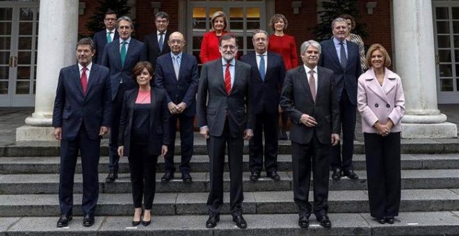 El jefe del ejecutivo, Mariano Rajoy, durante la foto oficial de su nuevo Ejecutivo tras la incorporación de Román Escolano, arriba a la izquierda. | EMILIO NARANJO (EFE)