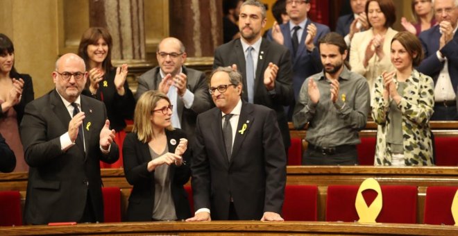 Quim Torra, al costat d'Elsa Artadi i Eduard Pujol, rep els aplaudiments dels diputats de JxCat, després de ser investit com a nou president de la Generalitat. / Parlament de Catalunya