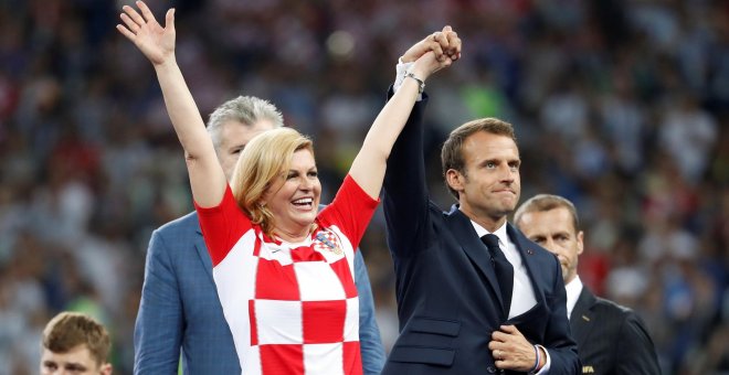 Emmanuel Macron levanta la mano de la presidenta de Croacia Kolinda Grabar-Kitarovic. REUTERS