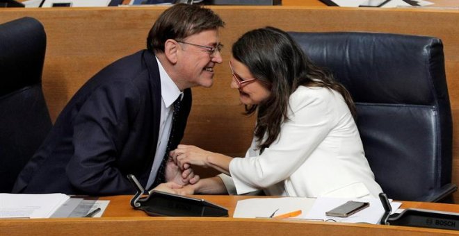 El candidato a la reelección como president de la Generalitat, Ximo Puig, y la vicepresidenta en funciones, Mónica Oltra, se dan la mano tras su discurso de investidura en Les Corts Valencianes. /EFE