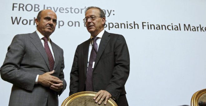 El ministro de Economía, Luis de Guindos, acompañado por el director general del Fondo de Reestructuración Ordenada Bancaria (FROB), Antonio Carrascosa, durante el acto de clausura de una jornada de trabajo organizada por esta entidad sobre el sistema fin