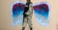 Un soldado camina ante un graffiti que representa las alas de un ángel, realizado por el artista Colette Miller, en Ciudad Juárez (México). /JOSÉ LUIS GONZÁLEZ (REUTERS)