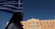 Una manifestante sostiene una bandera griega en frente del Parlamento.-Yannis Kolesidis (EFE)