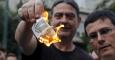 Dos personas queman unos billetes de euro en una manifestación anti austeridad frente a las oficinas de la Comisión Europea en Bruselas. REUTERS/Alkis Konstantinidis