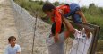 Refugiados kurdos sirios pasan un niño sobre una cerca en la frontera húngaro-serbia, cerca Ásotthalom, Hungría .- REUTERS / Laszlo Balogh