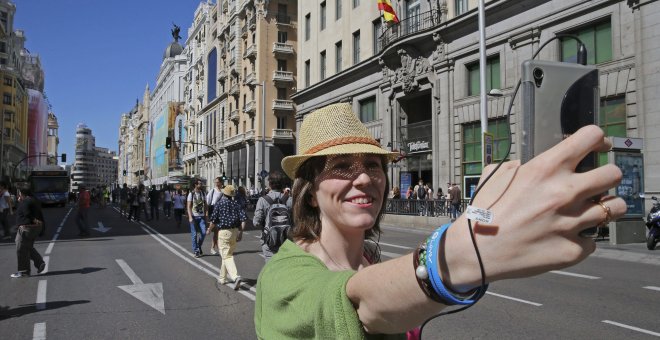 Una mujer se hace una fotografía en la Gran Vía de Madrid cerrada al tráfico con motivo del Día Sin Coches que, además de Madrid, celebran Valladolid, San Sebastián, y Valencia, entre 330 ciudades, con acciones que van desde limitar el tráfico privado en