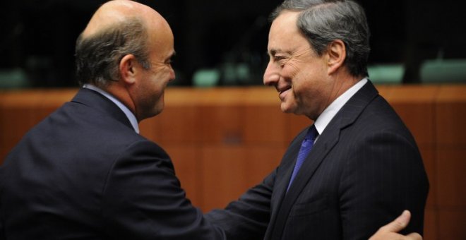 El ministro de Economía, Luis de Guindos, saluda al presidente del BCE, Mario Draghi, en una reunión del Eurogrupo en Bruselas. AFP/ JOHN THYS