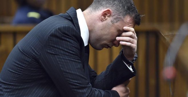 El atleta sudafricano Oscar Pistorius permanece sentado en el banquillo de los acusados durante una vista para dictar la pena que debe cumplir por el asesinato de su novia, en el Tribunal Superior del Norte de Gautengal en Pretoria, Sudáfrica. EFE/Phill M