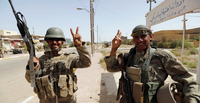 Soldados iraquíes saludan en el centro de Faluya, Irak. REUTERS/Thaier Al-Sudani