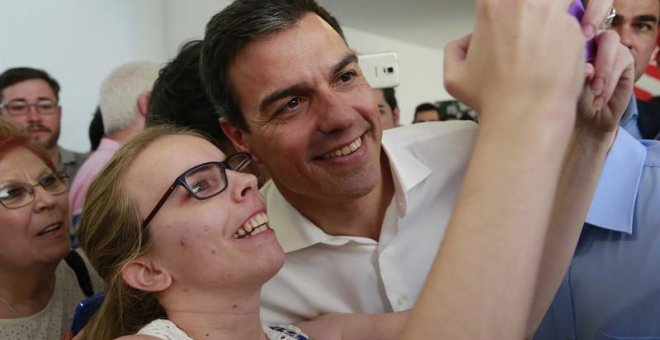 El secretario general del PSOE, Pedro Sánchez, se hace una fotografía con una simpatizante durante el acto electoral con las Juventudes Socialistas, en el Centro Cultural Tomás y Valiente, en la localidad madrileña de Fuenlabrada./ EFE