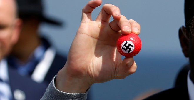 Un manifestante sostiene una pelota de golf con una esvástica dibujada en una rueda de prensa del candidato presidencial republicano Donald Trump en Turnberry Campo de golf en Turnberry , Escocia.- REUTERS / Carlo Allegri