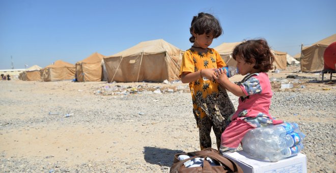 Niños iraquíes migrantes desde Siria reciben suministros de ayuda en un campamento de refugiados en Baiji, al norte de Bagdad. REUTERS/Stringer